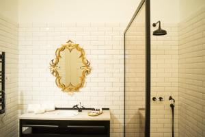 a bathroom with a sink and a mirror on the wall at Conquistador Palace in Guimarães