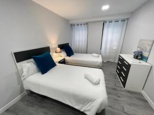 a small bedroom with two beds and a night stand at DAU Centro Free Parking in Salamanca