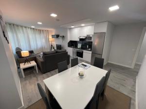 a kitchen and living room with a white table and chairs at DAU Centro Free Parking in Salamanca