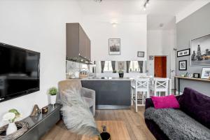 a living room with a couch and a kitchen at Lumina apartments on the market square near the Royal Castle in Warsaw
