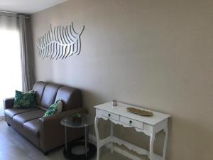een woonkamer met een bank en een tafel bij Beach Way - Apartamento no Porto das Dunas in Fortaleza