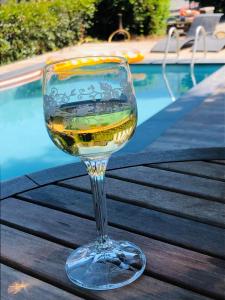 ein Glas Wein auf einem Tisch neben einem Pool in der Unterkunft B &B Yuupke Maasbree Noord-Limburg Venlo Roermond in Maasbree