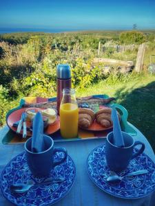 une table avec deux tasses et une assiette de nourriture dans l'établissement Coquet Nid douillet ...Slow Life, à Plogoff