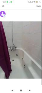 a bathroom with a bath tub with a purple shower curtain at Logement tout confort Vernet les Bains à côté des thermes in Vernet-les-Bains