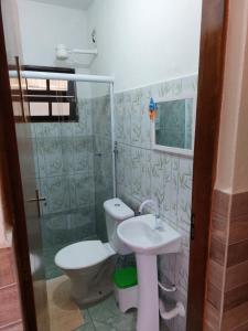 a bathroom with a toilet and a sink at Pousada Morena Raiz in Ubatuba