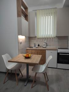 cocina con mesa de madera y 2 sillas en Ana Belgrade Apartments, en Belgrado