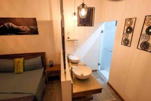 mała łazienka z łóżkiem i umywalką w obiekcie Mungur villa w mieście Flic-en-Flac