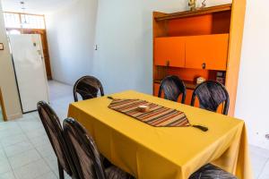 a yellow table in a kitchen with chairs and a refrigerator at Casa Rosa in San Juan +4 photos