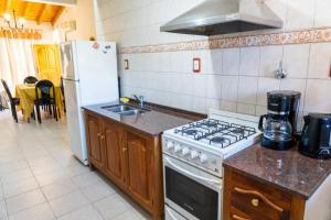 a kitchen with a stove and a sink and a refrigerator at Casa Rosa in San Juan