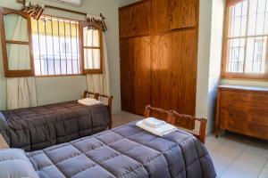 a bedroom with two beds and a dresser and windows at Casa Rosa in San Juan