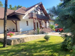 a house with a balcony and a yard at Kozi Lasek in Koluszki