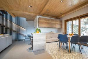 a kitchen with wooden ceilings and a table and chairs at La Quintana Berbes By Silastur in Ribadesella