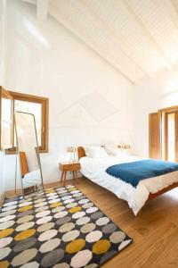 a bedroom with a large bed and a rug at La Quintana Berbes in Ribadesella