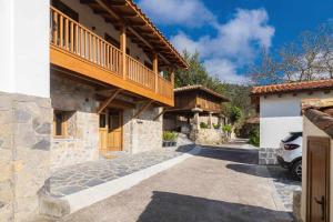 una casa con un balcón en el lateral. en La Quintana Berbes, en Ribadesella