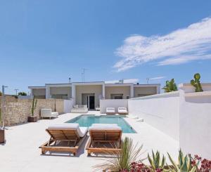 Una piscina con dos tumbonas y una casa. en Villa Skyline- Otranto, en Otranto