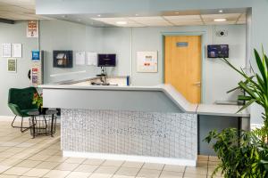 a hospital lobby with a reception counter with a door at ibis budget Sheffield Arena in Sheffield