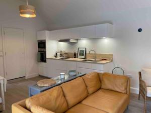 a living room with a couch and a kitchen at The Coach House, Clonakilty in Clonakilty