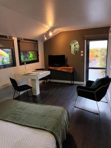 a bedroom with a bed and a table and a desk at Chambre d'Hotes "Riad des Baudières" in Bourg-en-Bresse