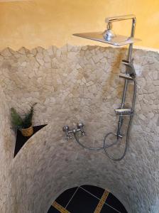 a shower in a bathroom with a stone wall at Ferienhaus Hexenhäuschen in Walhausen