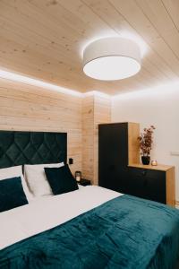 a bedroom with a large bed and a large light fixture at SKRI Chalets in Liptovský Mikuláš