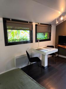 een kleine kamer met een bureau en 2 ramen bij Chambre d'Hotes "Riad des Baudières" in Bourg-en-Bresse