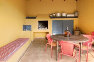 a dining room with a table and pink chairs at Casa Cristina in Junqueira