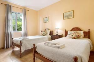 1 dormitorio con 2 camas y ventana en Casa Cristina, en Junqueira