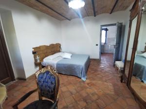 a bedroom with a bed and a chair and a mirror at Domus Nirale in Bagnoregio