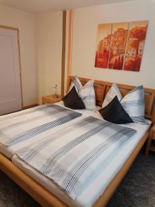 una gran cama blanca con almohadas encima en Ferienwohnung Hohe Wand, en Heiligenblut