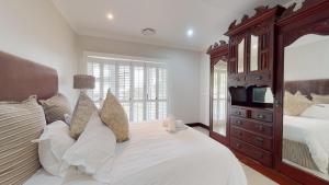 a bedroom with a large bed and a large mirror at Khumbula at Caribbean Estates in Port Edward