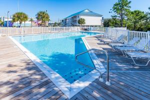 una piscina con sillas en una terraza de madera en Palmettos #104 en Orange Beach