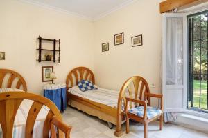 a bedroom with a bed and chairs and a window at El Mirlito in Roche