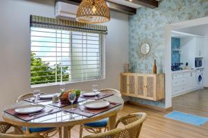 a dining room with a table and chairs and a window at Hoodo - HBR Layout Bangalore Apartments in Bengaluru