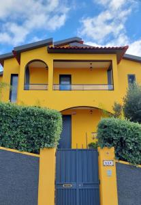a yellow house with a blue gate at Villa Strelitzia in Funchal