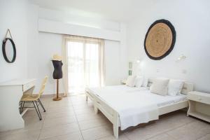 a white bedroom with a white bed and a desk at Rosie's Studio 3 in Faliraki
