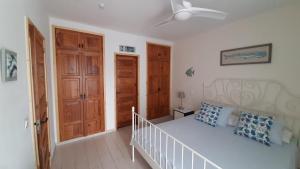 sypialnia z białym łóżkiem i drewnianymi drzwiami w obiekcie El Gueco Holiday Apartment w Costa Teguise +30 zdjęć