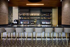 a bar in a hotel with stools in front of it at Archer Hotel Falls Church in Fairfax +48 photos