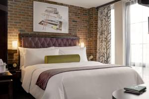 a bedroom with a large bed and a brick wall at Archer Hotel New York in New York