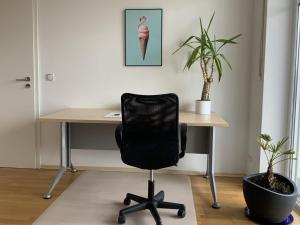 un bureau avec un bureau et une chaise noire dans l'établissement Apartment „Am Südhang“, à Odelzhausen