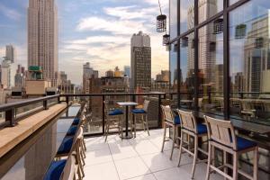 a balcony with chairs and a view of the city at Archer Hotel New York in New York