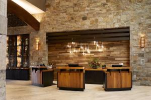 a lobby with a bar with a stone wall at Archer Hotel Napa in Napa
