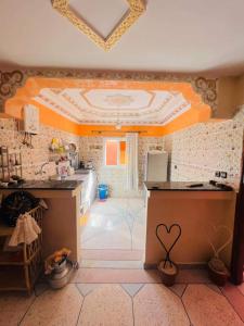 una cocina con paredes de color naranja y un techo con un corazón. en Atlantic house, en Tamraght Ouzdar