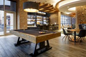 a pool table in a room with a bar at Archer Hotel Boston/Burlington in Burlington