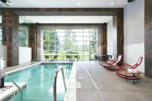 a pool with chairs and tables in it at Archer Hotel Seattle/Redmond in Redmond