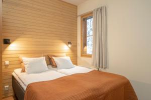 a bedroom with a large bed with a window at Ski-Inn AurinkoRinne in Ruka