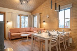 sala de estar con sofá, mesa y sillas en Ski-Inn AurinkoRinne en Ruka