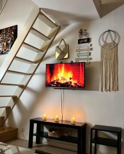 sala de estar con chimenea en la pared en SPA APPARTEMENT en Ermont