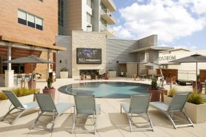 a patio with chairs and a pool and a building at Archer Hotel Austin in Austin