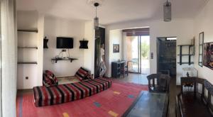 een woonkamer met een bank en een tv bij Maison d hôtes Bungalow Villa Hammam Bien-être et Piscine in Agadir