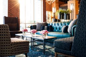 a living room with a couch and two chairs and tables at Archer Hotel Tysons in Tysons Corner